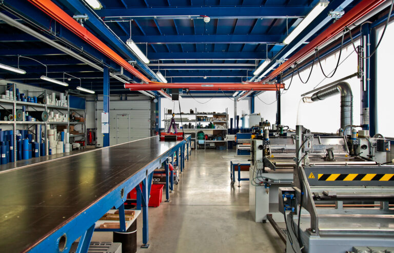 Produktionshalle mit Maschinen und Arbeitstischen